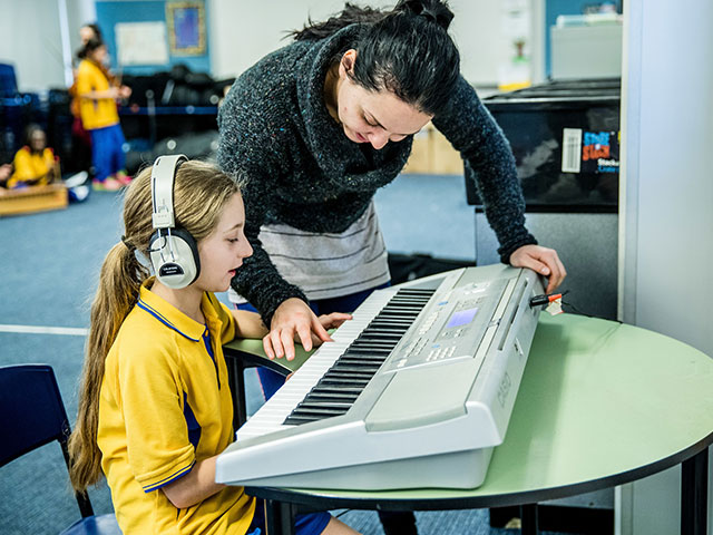 Music teacher with student at St Michael's Primary Blacktown