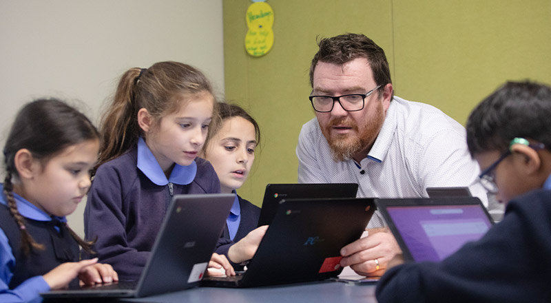 Students learning together with their teacher at St Michael's Primary School Blacktown South