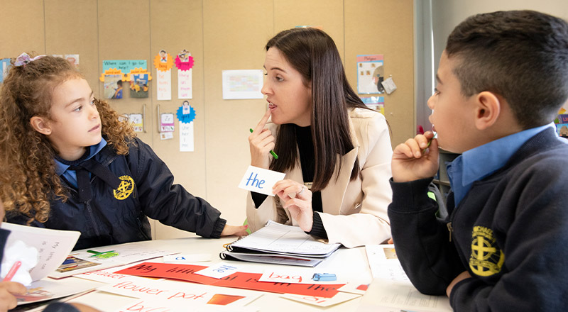 Teacher with her students teaching them literacy at St Michael's Primary School Blacktown South