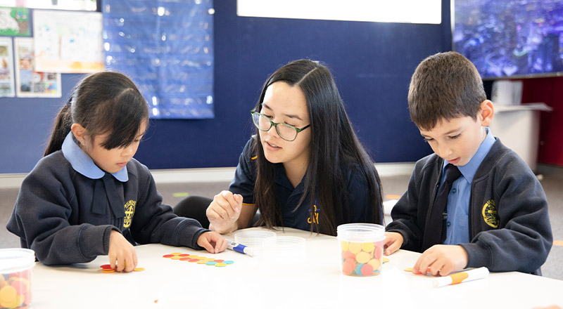Students learning maths with their teacher in the classroom at St Michael's Primary School Blacktown South