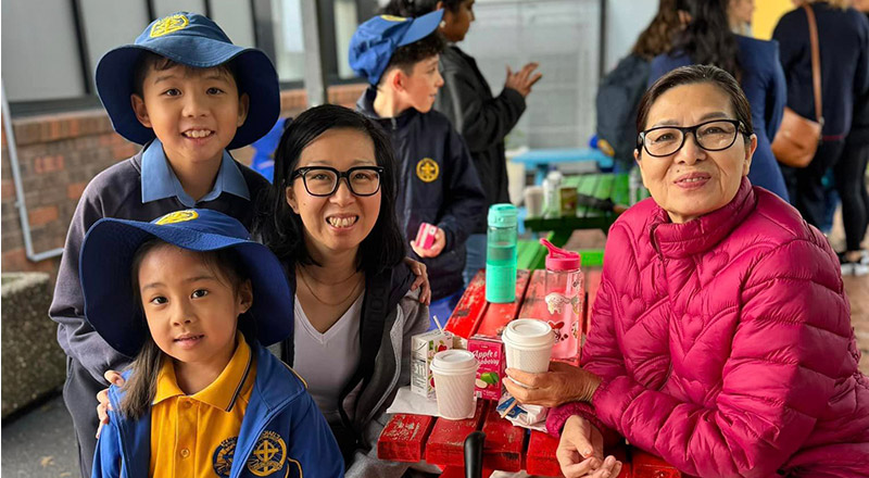 Students with their parents at a school celebration at St Michael's Primary School Blacktown South