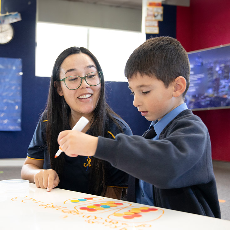 Student with his teacher learning math at St Michael's Primary School Blacktown South