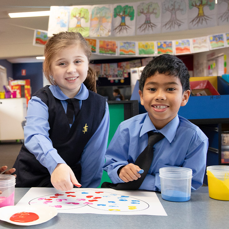 Students finger painting together in the classroom at St Michael's Primary School Blacktown South