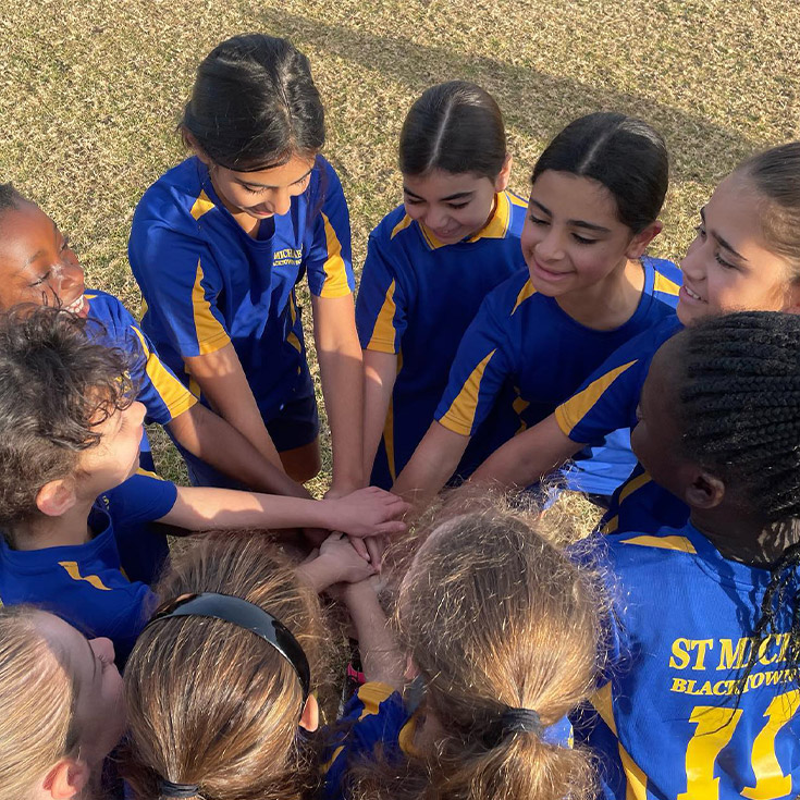 The St Michael's Primary School Blacktown South representative sports team in a huddle before a game