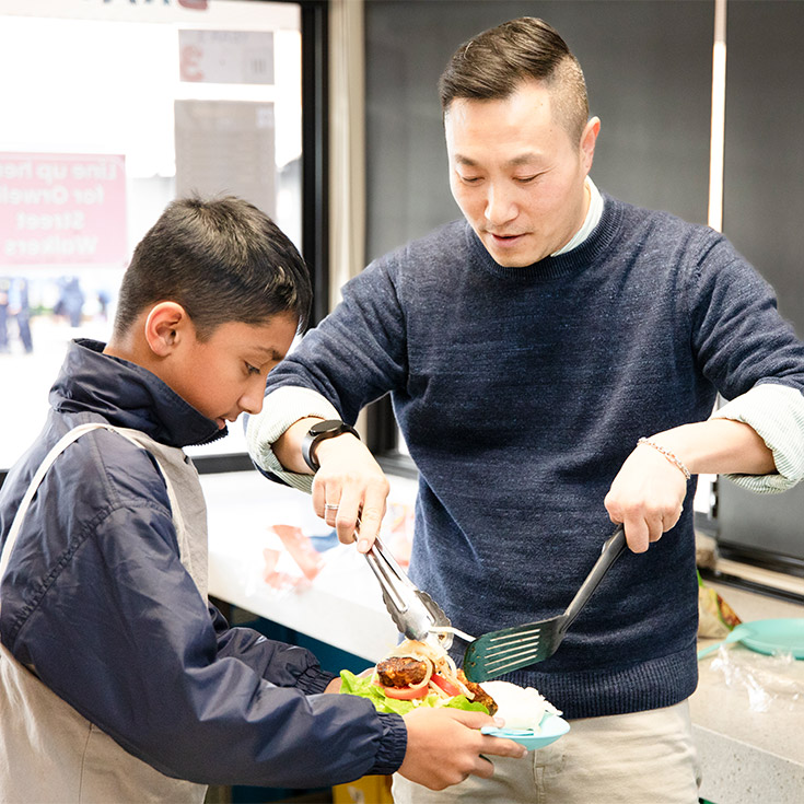 Teacher and student in a cooking class at St Michael's Primary School Blacktown South