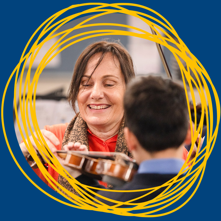 Teacher teaching student how to play the violin at St Michael's Primary School Blacktown South