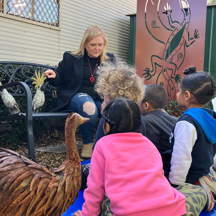 Children enrolled to attend St Michael's Primary School Blacktown South learning outside with an educator at the Ambrose Early Learning Centre