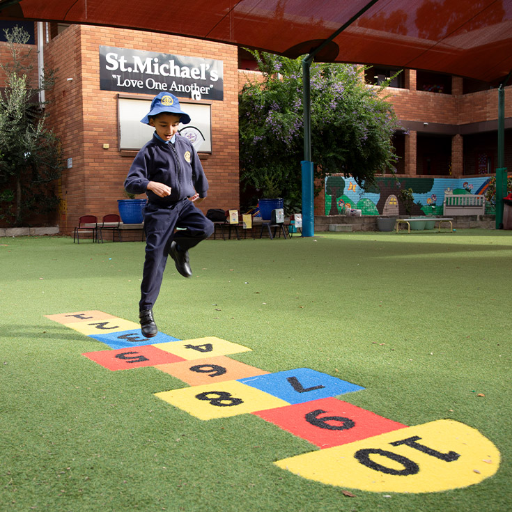 Student playing hop scotch in the playground at St Michael's Primary School Blacktown South
