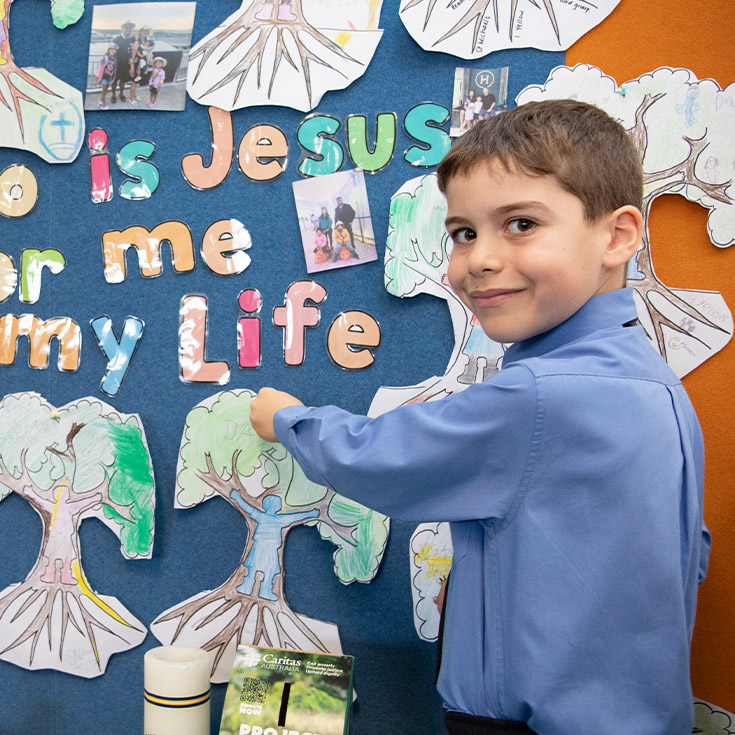 Student hanging an artwork in religion class at St Michael's Primary School Blacktown South