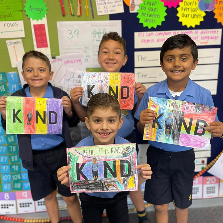 Students holding Be Kind posters they created to support charity at St Michael's Primary School Blacktown South