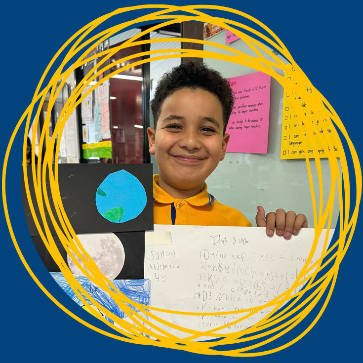 Student showcasing his school work in the classroom at St Michael's Primary School Blacktown South