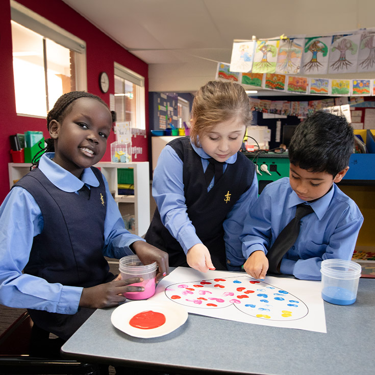 Students painting in the classroom at St Michael's Primary School Blacktown South