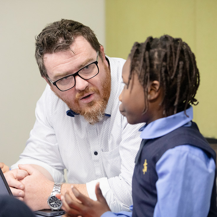 Teacher with student in class at St Michael's Primary School Blacktown South