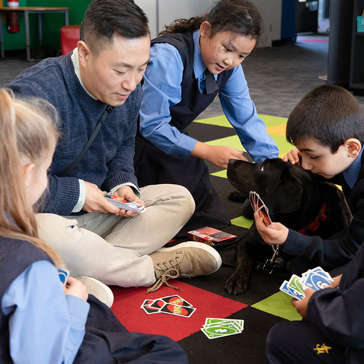 Teacher and students playing UNO at St Michael's Primary School Blacktown South
