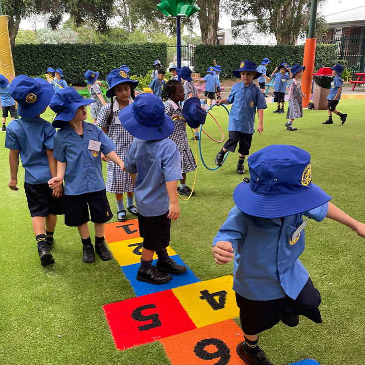 Students playing hopscotch in the school playground at St Michael's Primary School Blacktown South