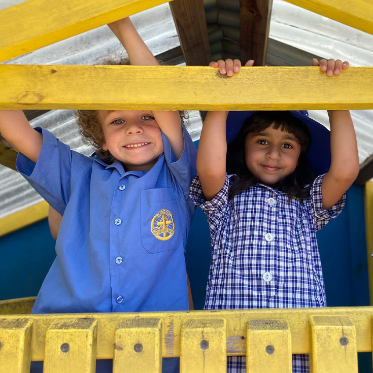 Students playing in a cubby house together at St Michael's Primary School Blacktown South