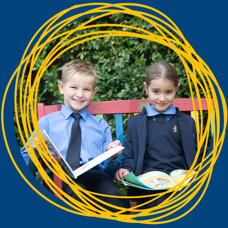 Students sitting on a bench with a book at St Michael's Primary School Blacktown South